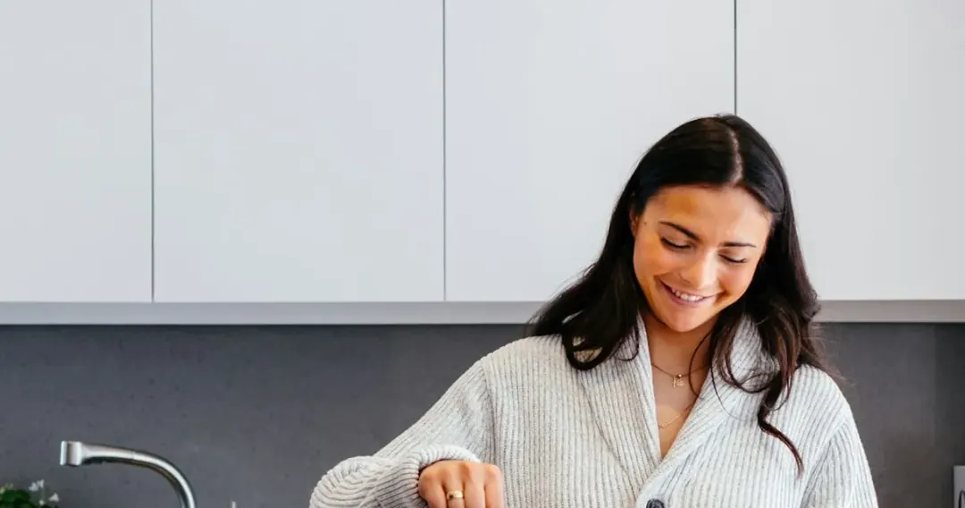 Mulher cozinhando em casa, em rotina alimentar do dia a dia
